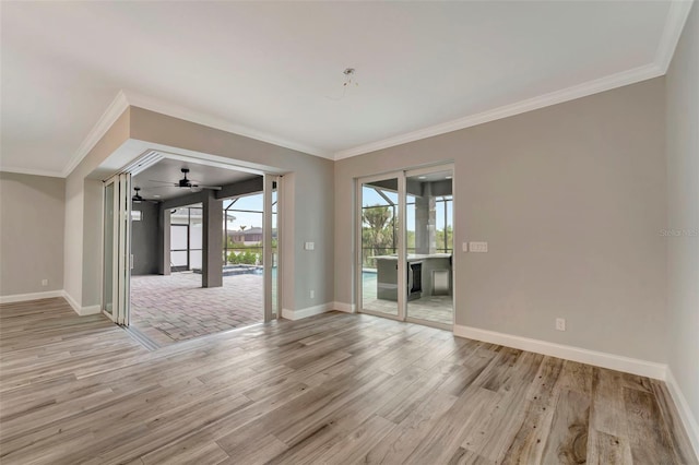 empty room featuring ornamental molding and light wood-type flooring