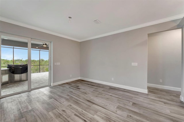 empty room with ornamental molding and light wood-type flooring