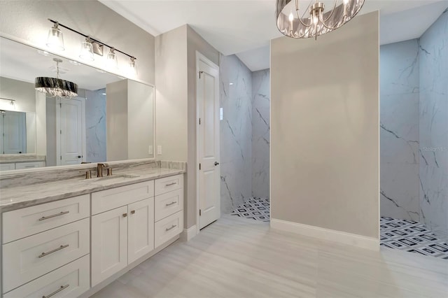 bathroom featuring vanity, a tile shower, and an inviting chandelier