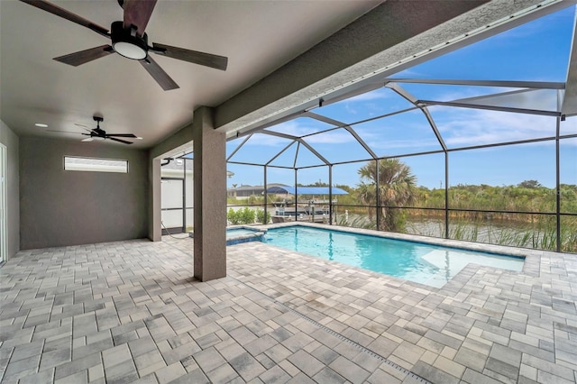 view of pool with ceiling fan, a patio, glass enclosure, and a water view