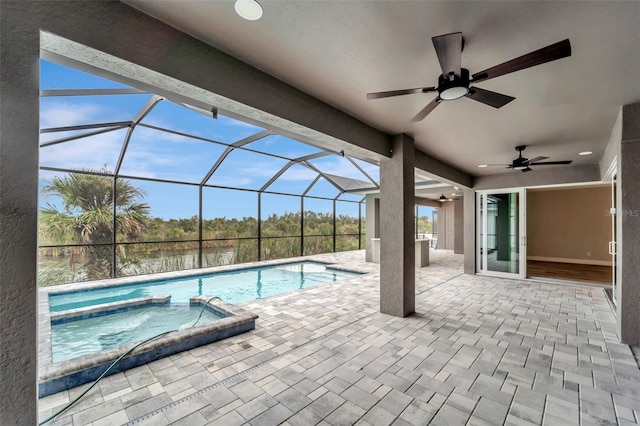 view of pool with an in ground hot tub, ceiling fan, a lanai, and a patio