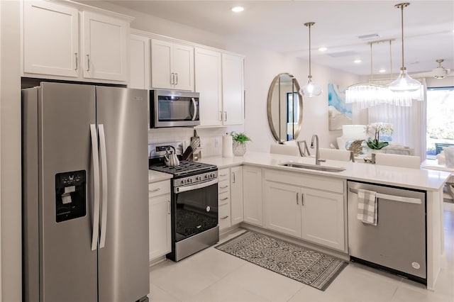 kitchen with sink, appliances with stainless steel finishes, white cabinetry, decorative light fixtures, and kitchen peninsula