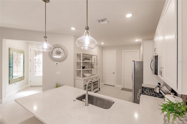 kitchen with white cabinetry, sink, pendant lighting, and kitchen peninsula