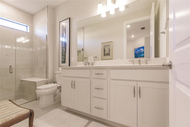 bathroom featuring vanity, a shower with door, and toilet