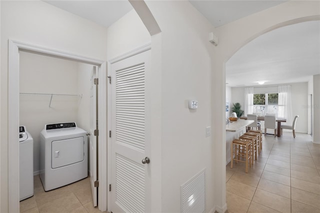 laundry area with light tile patterned floors and washer and clothes dryer