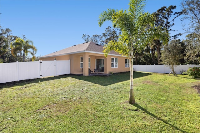 rear view of property with a lawn