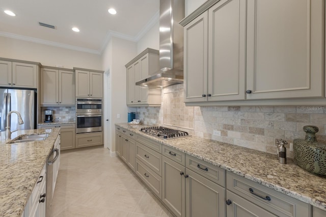 kitchen featuring stainless steel appliances, light stone countertops, sink, and wall chimney range hood