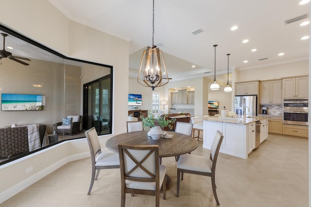 tiled dining area with crown molding, sink, and ceiling fan with notable chandelier