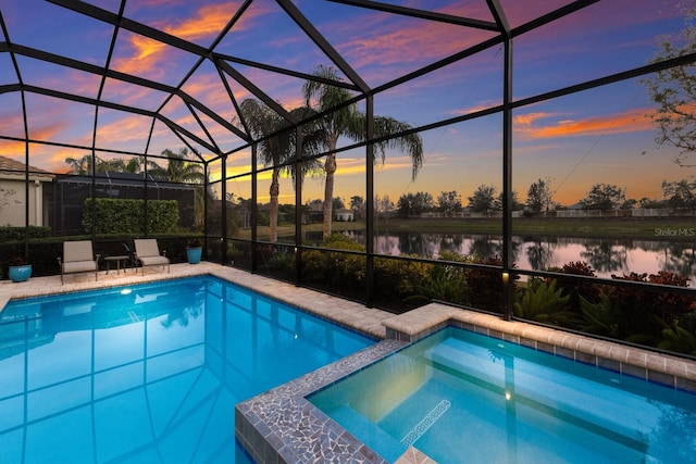 pool at dusk featuring a water view, an in ground hot tub, and a lanai