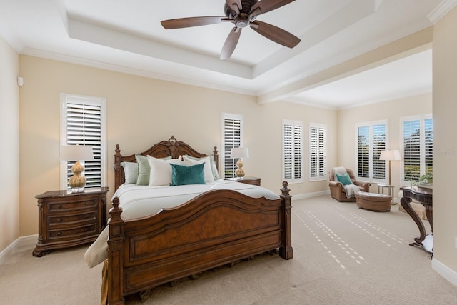 bedroom with ornamental molding, light carpet, and a tray ceiling