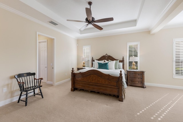 bedroom featuring multiple windows, light colored carpet, and a raised ceiling