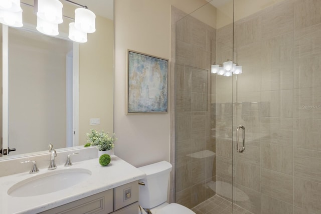 bathroom with vanity, a shower with door, and toilet