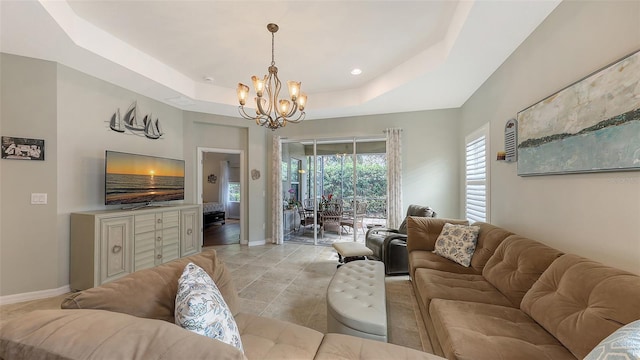 living room with a raised ceiling and a chandelier