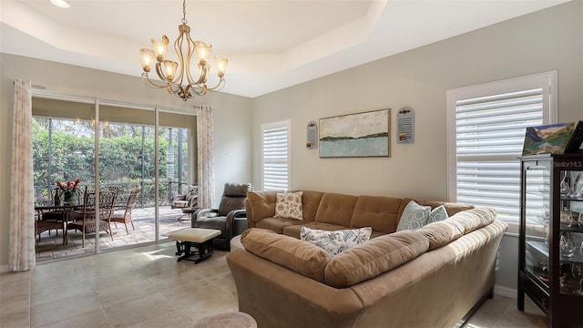 tiled living room featuring a raised ceiling and a chandelier