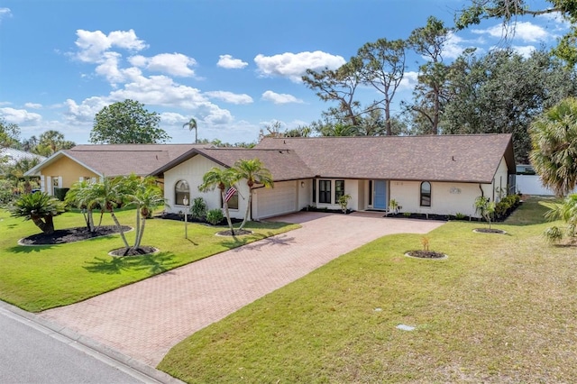 single story home featuring a garage and a front lawn