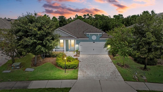 view of front of house with a yard and a garage