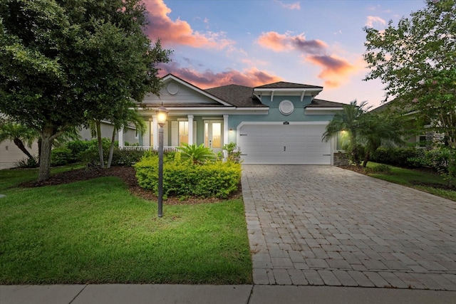 view of front of property with a garage and a yard