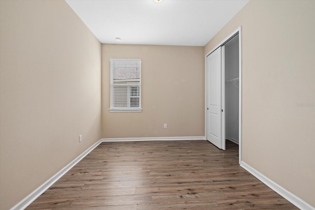 unfurnished bedroom featuring dark wood-type flooring and a closet