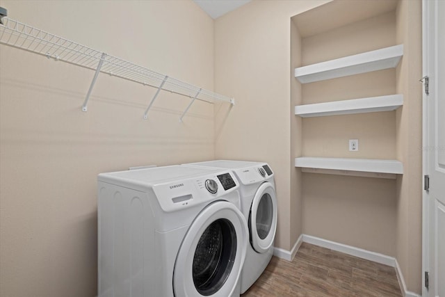 washroom featuring hardwood / wood-style flooring and washing machine and clothes dryer