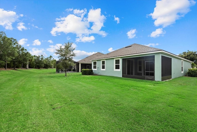 back of house with a lawn and a sunroom