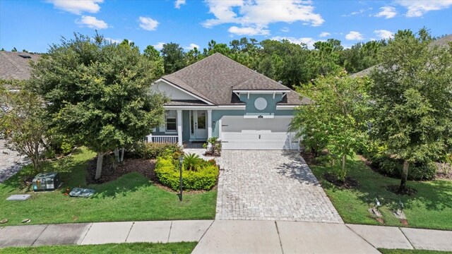 view of front of home with a garage, a porch, and a front yard