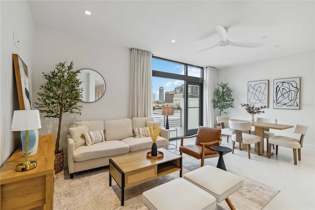 living room with ceiling fan and a wall of windows