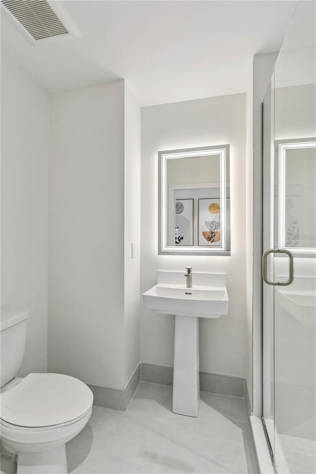 bathroom featuring walk in shower and toilet