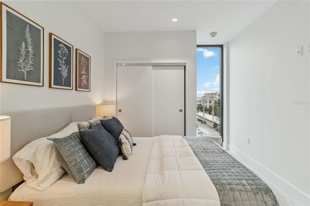 bedroom with a closet and floor to ceiling windows