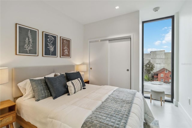 bedroom with floor to ceiling windows and a closet