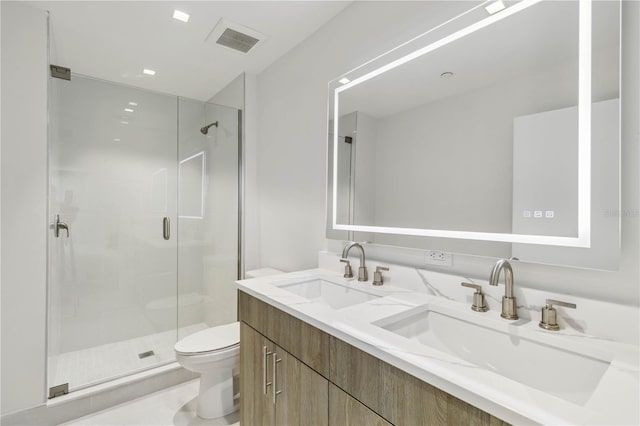 bathroom with vanity, a shower with shower door, and toilet