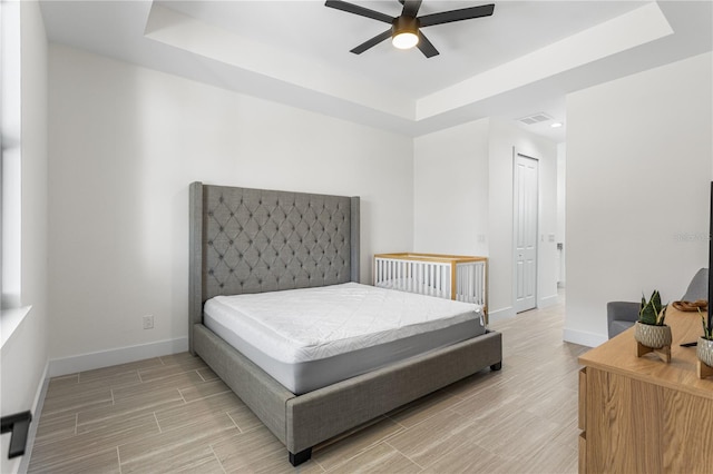 bedroom featuring ceiling fan and a raised ceiling