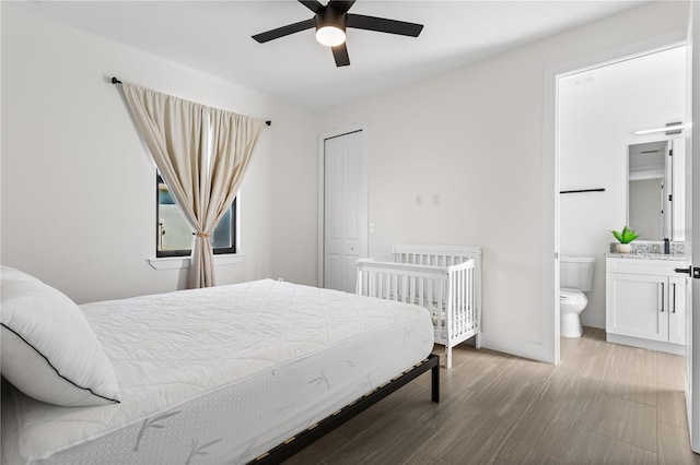 bedroom featuring light hardwood / wood-style floors, ceiling fan, and ensuite bathroom