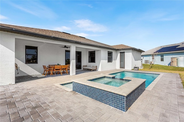 view of pool featuring a patio area, ceiling fan, and an in ground hot tub