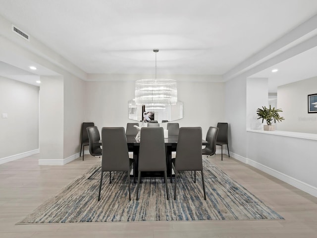 dining room with a notable chandelier and light wood-type flooring