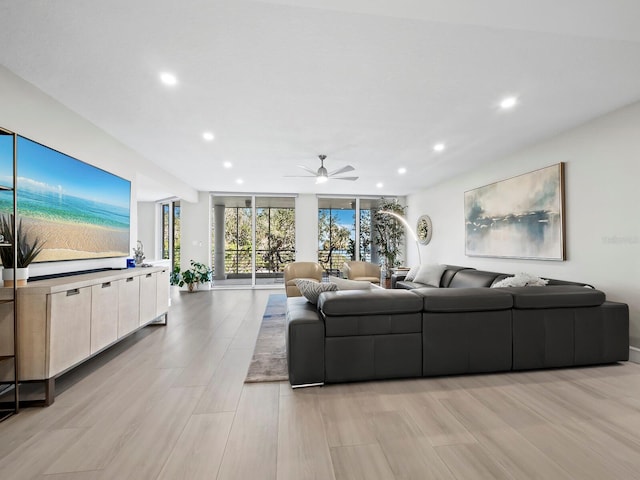 living room with light hardwood / wood-style floors, expansive windows, and ceiling fan