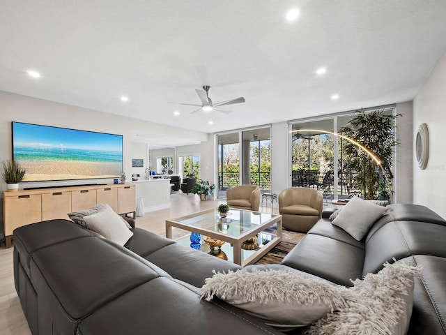 living room with floor to ceiling windows, ceiling fan, and light hardwood / wood-style floors