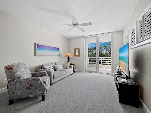 carpeted living room with ceiling fan, a wall of windows, and a textured ceiling