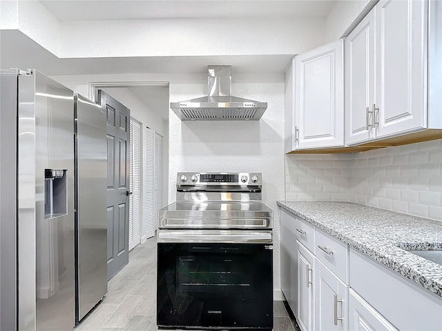 kitchen featuring exhaust hood, white cabinets, stainless steel appliances, light stone countertops, and backsplash