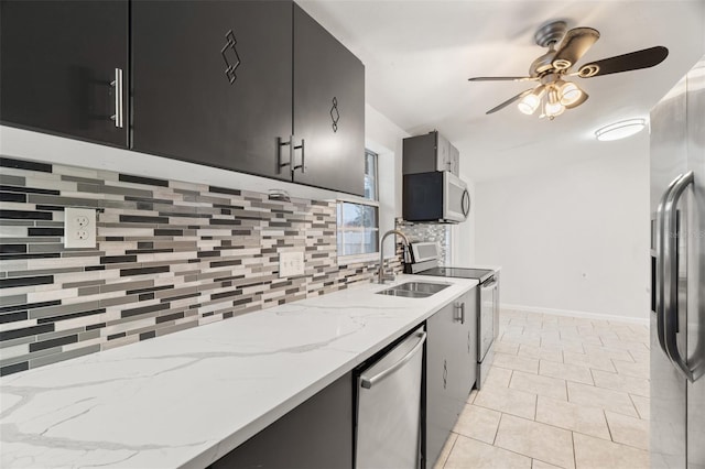 kitchen with appliances with stainless steel finishes, sink, decorative backsplash, ceiling fan, and light stone counters