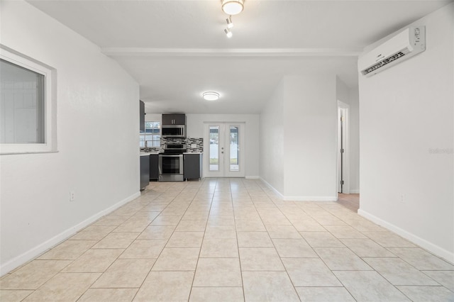 unfurnished living room featuring a wall mounted air conditioner, french doors, beamed ceiling, and light tile patterned flooring