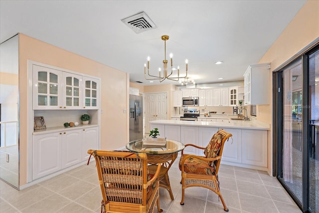 dining space featuring an inviting chandelier, sink, and light tile patterned flooring