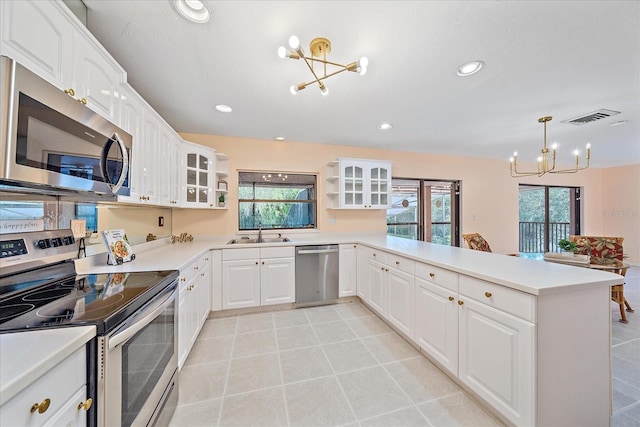 kitchen with white cabinetry, stainless steel appliances, kitchen peninsula, and a chandelier