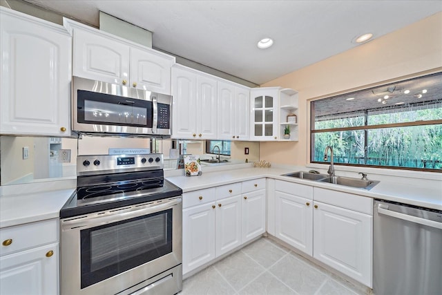 kitchen with white cabinetry, sink, light tile patterned floors, and stainless steel appliances