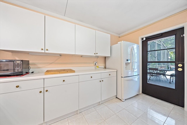 kitchen featuring white cabinetry, ornamental molding, white refrigerator with ice dispenser, and light tile patterned floors