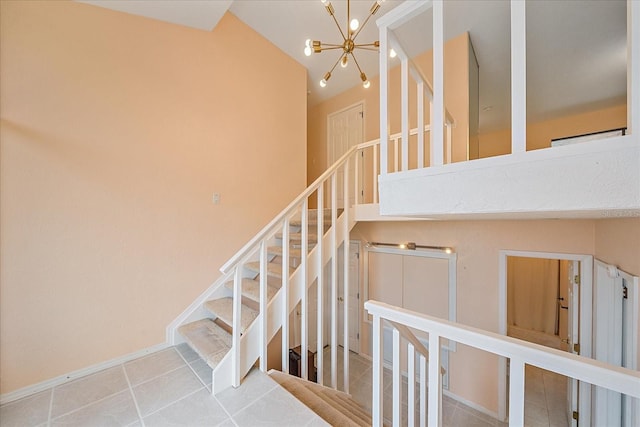 staircase with an inviting chandelier, tile patterned floors, and a high ceiling