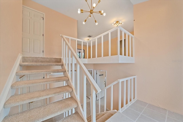 stairway featuring tile patterned flooring and a chandelier