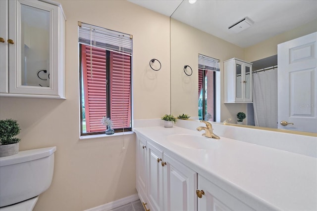 bathroom featuring vanity, a wealth of natural light, and toilet