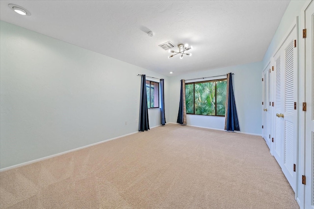 unfurnished bedroom featuring light colored carpet and a textured ceiling