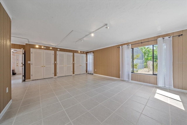 empty room with wood walls and light tile patterned floors