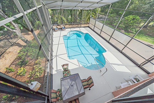 view of swimming pool with glass enclosure and a patio area